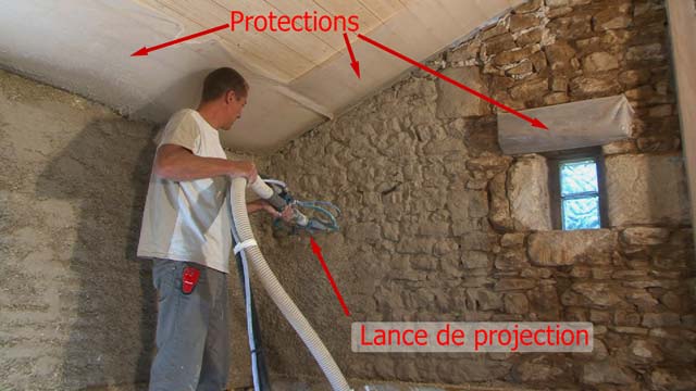 Projection de l'enduit chaux-chanvre à l'intérieur de la maison